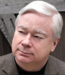 A man with gray hair looks off into the distance