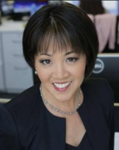 A woman with short, black hair smiles into the camera.