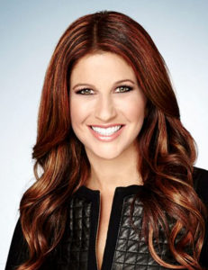 A woman with red hair smiles at the camera