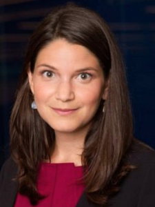 A woman with brown hair stares at the camera