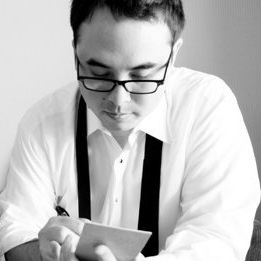 A man with glasses stares at his reporter's notebook