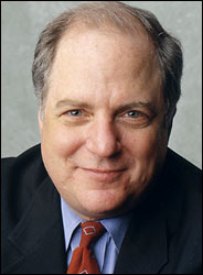 A man in a suit poses for a headshot