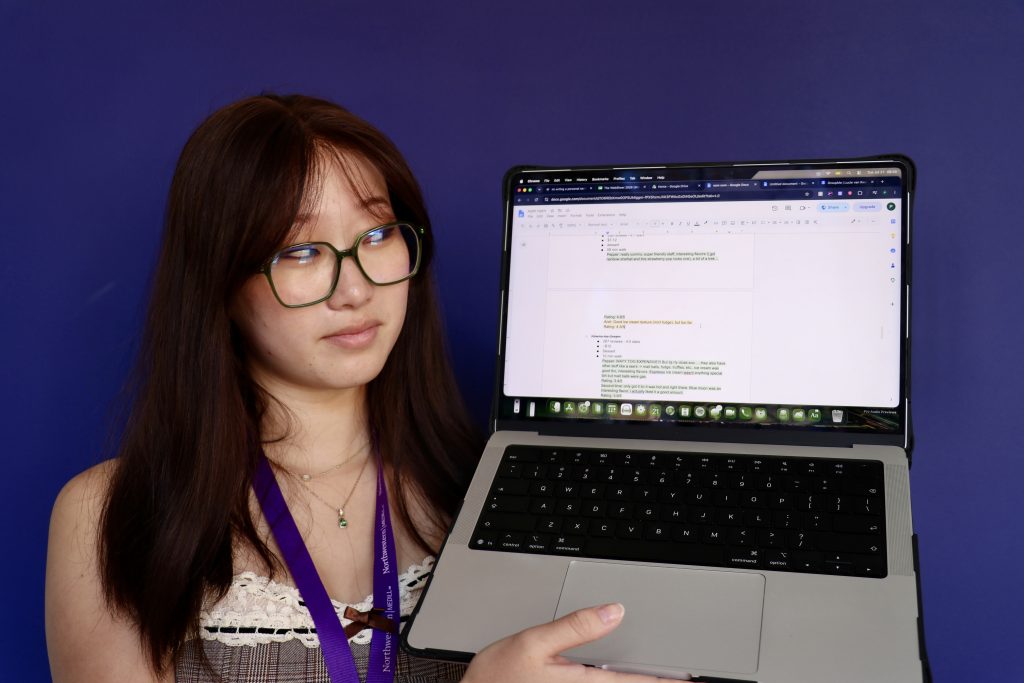 A person holds up a computer and looks at it.