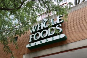 A Whole Foods sign hangs on a red brick building.