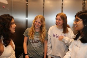 Four people stand in an elevator.